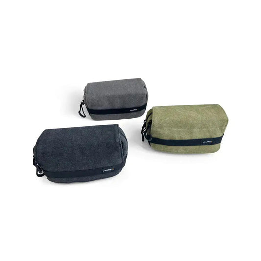 Three Vaultlax waterproof canvas pouches in dark gray, olive green, and charcoal black, arranged on a clean white background.